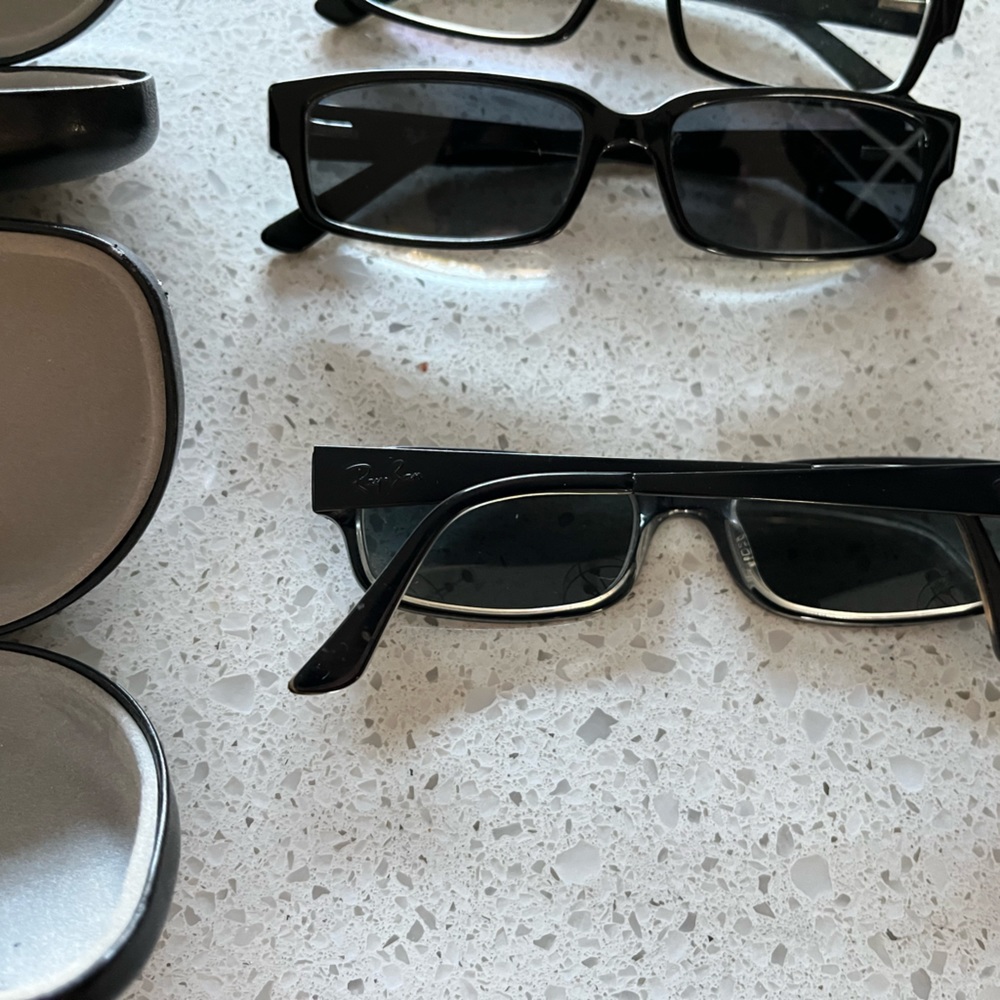 Three pairs of prescription Ray Ban glasses.